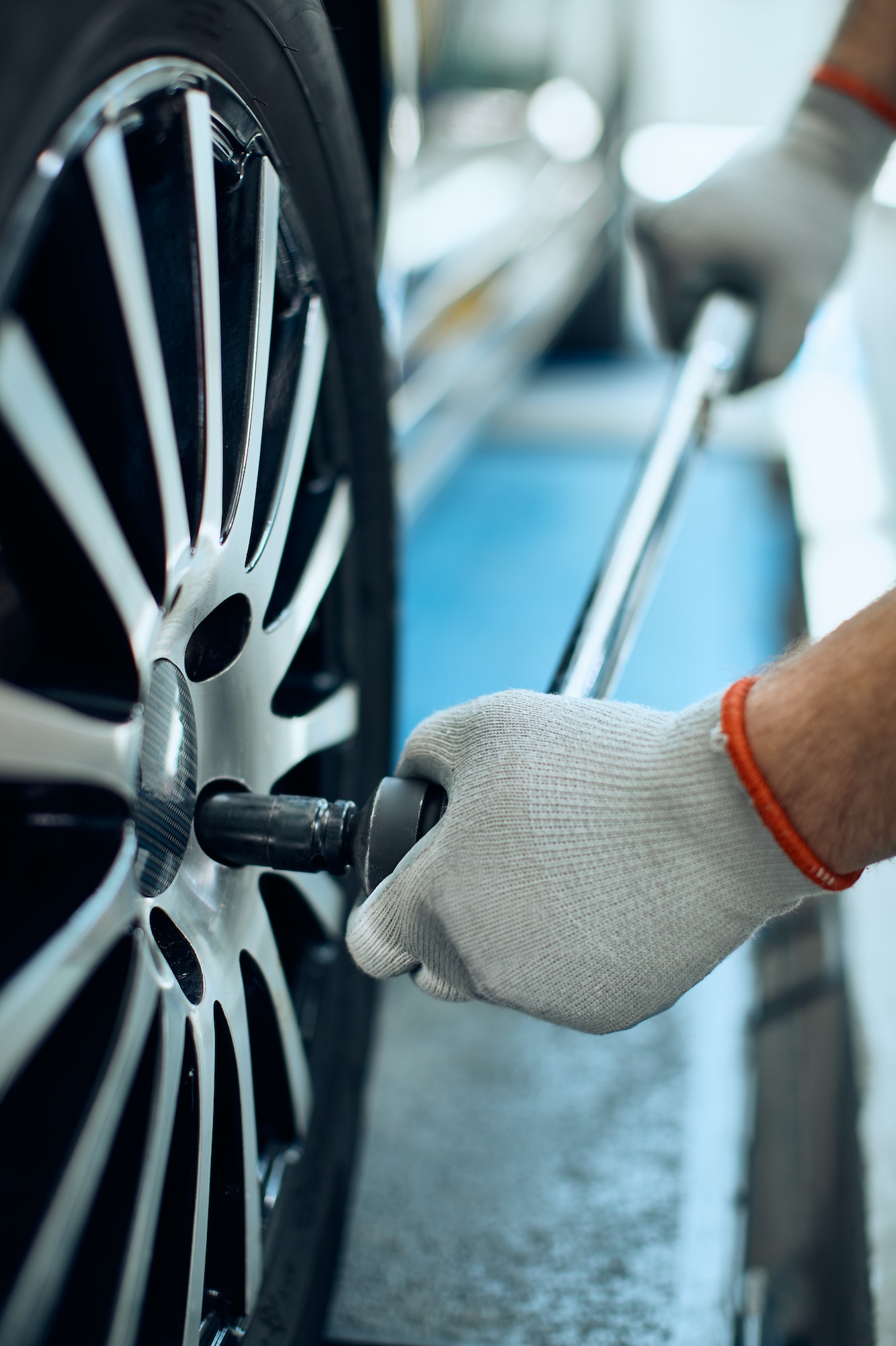 Close-up of mechanic changing car tire at auto repair shop.